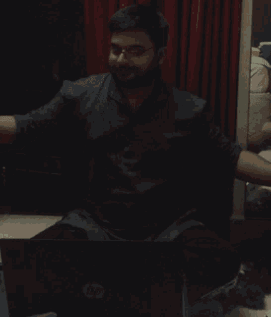 a man with a beard sits in front of a laptop that says lg on it