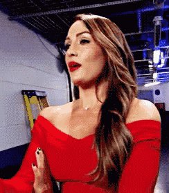 a woman in a red off the shoulder dress is standing in a hallway .