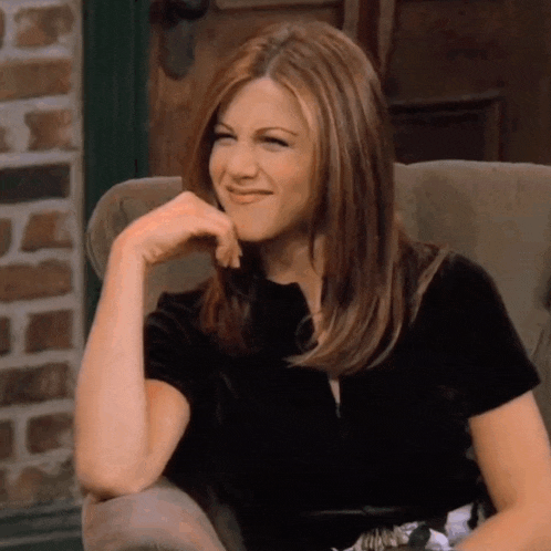 a woman is sitting in a chair with her hand on her chin and smiling