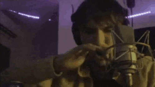 a man in headphones is singing into a microphone .