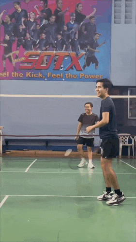 a blurry picture of a person playing badminton with a picture of a bird on the wall behind them