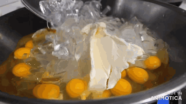 eggs and butter are being cooked in a pan that says made in animotica