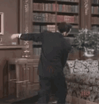 a man in a tuxedo dancing in a living room