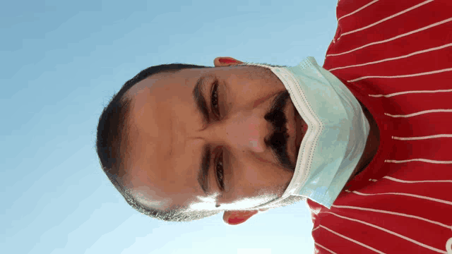 a man wearing a mask and a red striped shirt