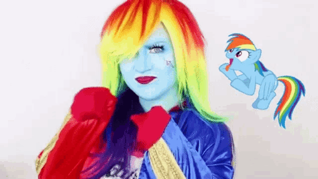 a woman in a rainbow dash costume is standing next to a rainbow dash pony