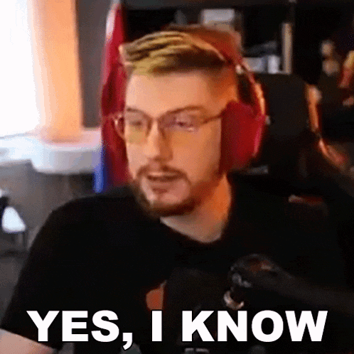 a man wearing headphones and glasses is sitting in front of a microphone and saying yes , i know .