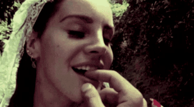 a close up of a woman 's face with a man 's finger on her mouth