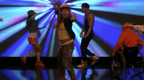 a man in a wheelchair is dancing in front of a group of people