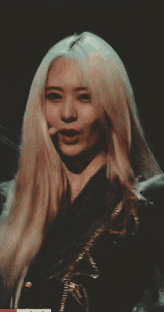 a woman with long blonde hair and red lips is holding her hair
