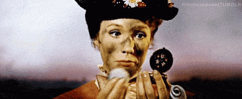 a woman in a hat is applying makeup to her face
