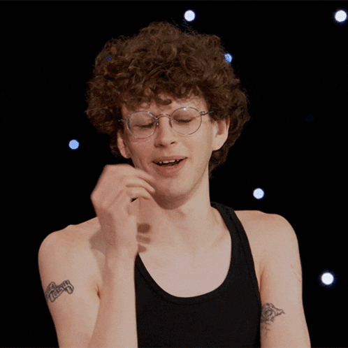 a man with curly hair and glasses has a tattoo on his arm that says ' chicago '