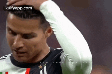 a soccer player is holding his hand to his forehead .
