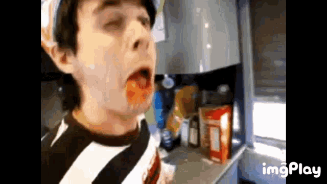 a man is eating a box of cereal in a kitchen