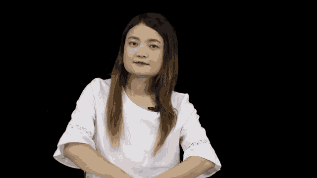 a woman in a white shirt is making a peace sign with her hands