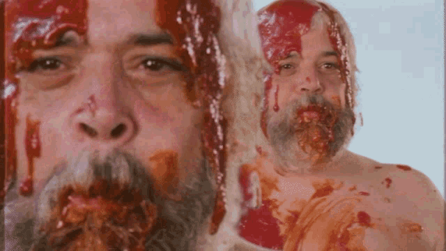 a man with a beard is covered in red sauce