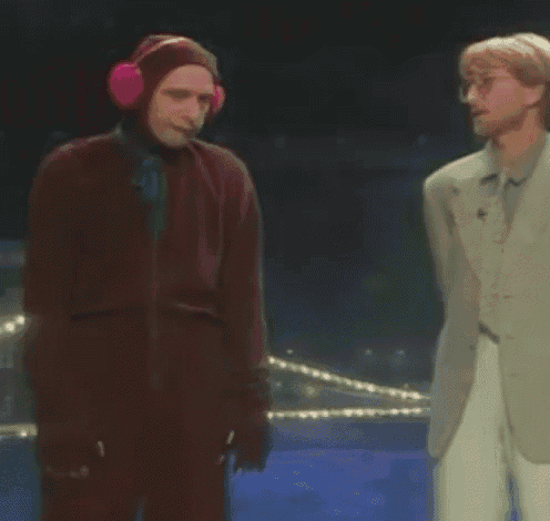 two men are standing next to each other on a stage .