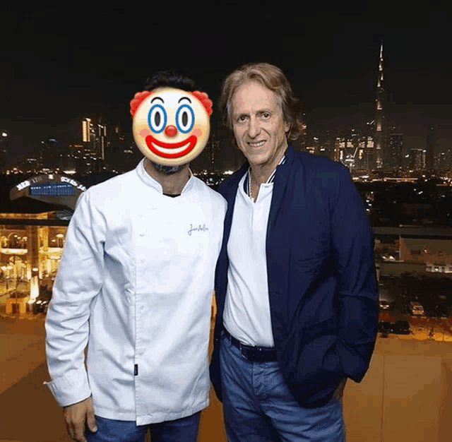 a man with a clown face on his face poses with another man