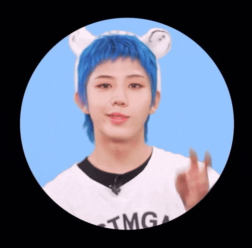 a person with blue hair wearing a tmg t-shirt