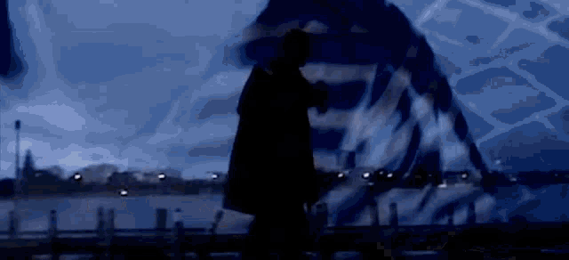 a silhouette of a person standing in front of a blue background