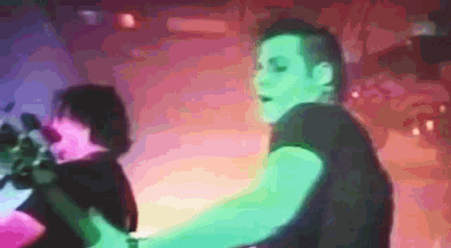 a blurry picture of a man in a green shirt playing a guitar