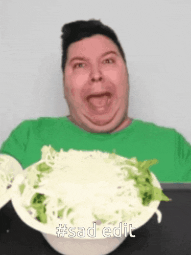 a man in a green shirt is holding a bowl of food with #sad edit written on the bottom