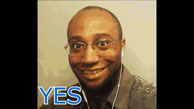 a man wearing glasses and ear buds is smiling and the word yes is on the bottom