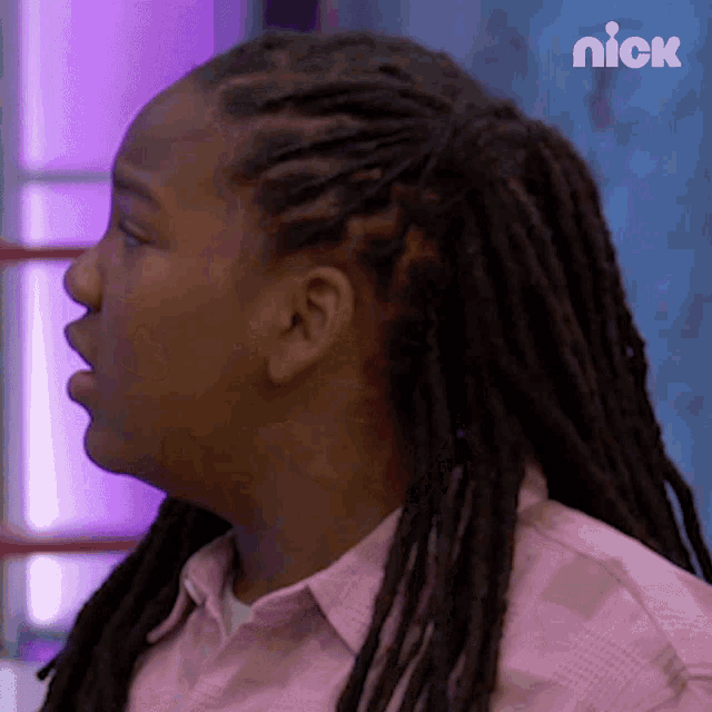 a girl with dreadlocks is wearing a pink shirt and a nick logo on the bottom