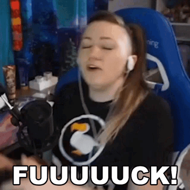 a woman wearing headphones is sitting in front of a microphone with her eyes closed and the words fuuuuuuuck !