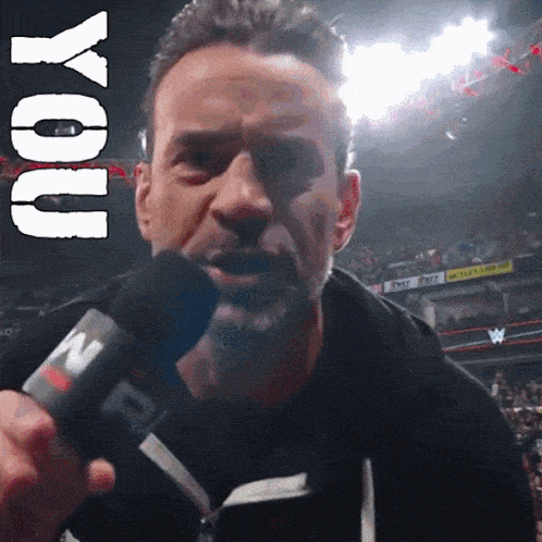 a man is holding a microphone with the word you above him