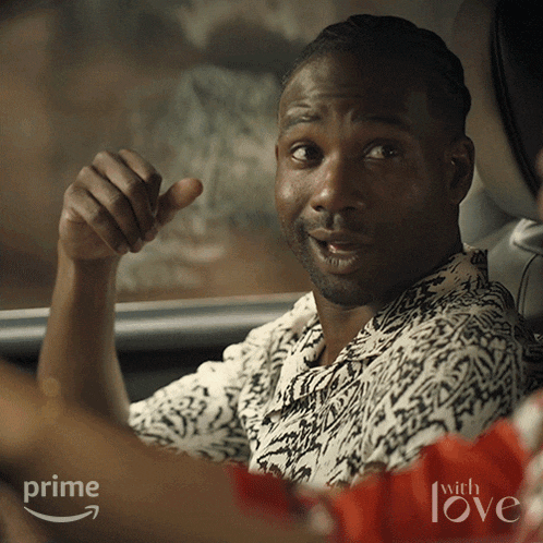 a man sitting in a car with the words prime with love behind him