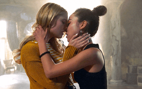 two women are kissing each other in a dark room