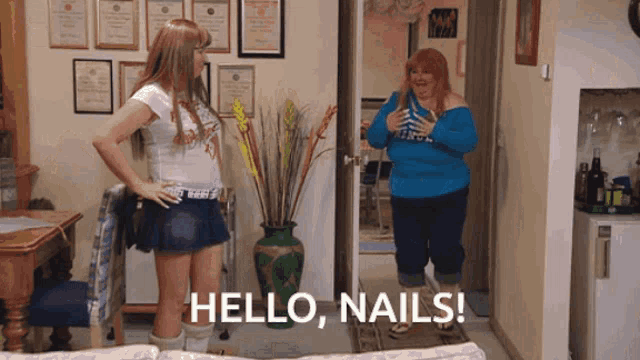two women standing in a living room with the words hello nails written on the bottom