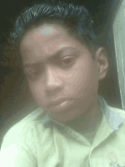 a young boy wearing a yellow shirt with a smiley face on it