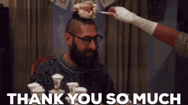 a man with a beard and glasses is getting a piece of cake on his head and the words thank you so much are below him .
