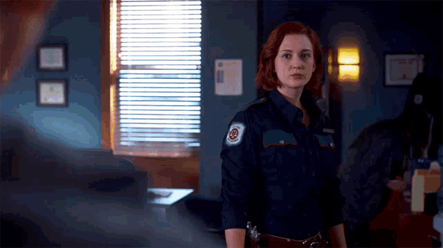 a woman in a police uniform has a patch on her arm that says ' emergency services '