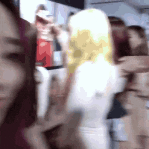 a blurry photo of a group of people including a blonde woman
