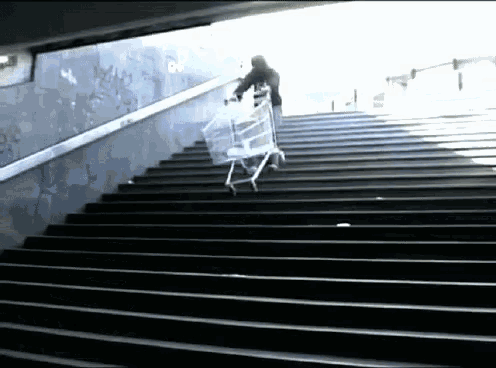 a man pushes a shopping cart up a set of stairs