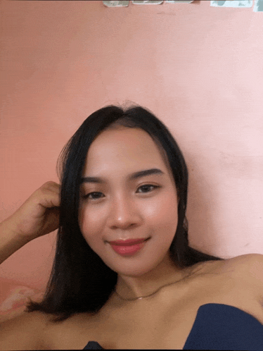 a woman in a blue top is smiling and looking at the camera