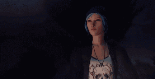 a man and a woman are standing next to each other in a dark room . the woman has blue hair .