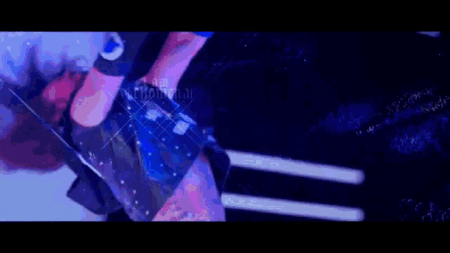 a female wrestler is hanging upside down in the air while wearing a black and blue outfit .