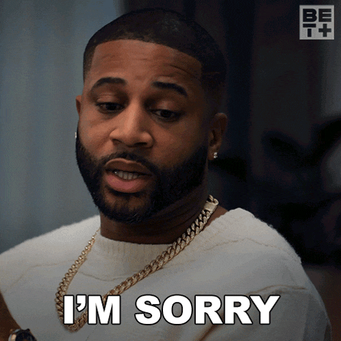 a man with a beard says i 'm sorry while wearing a white sweater