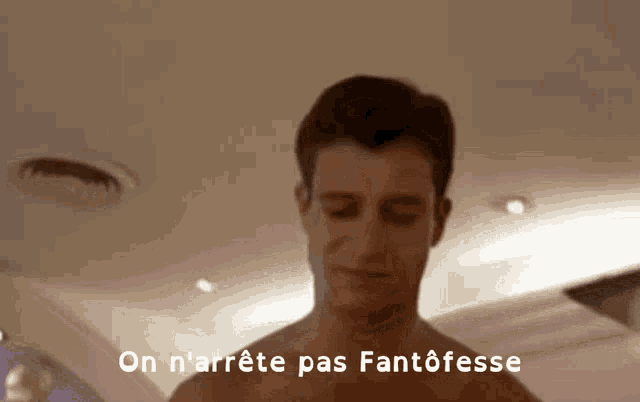 a shirtless man is standing in front of a sign that says on n'arret pas fantoffe