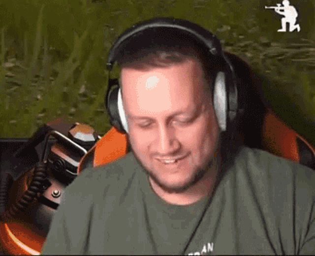 a man wearing headphones is sitting in front of a computer screen .