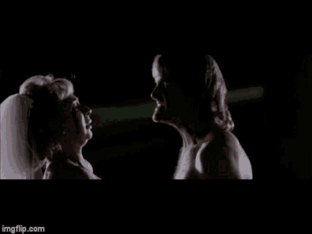 a man and a woman are standing next to each other in the dark .