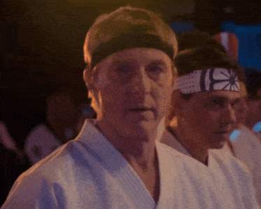 a man in a karate uniform has a headband with the letter i on it
