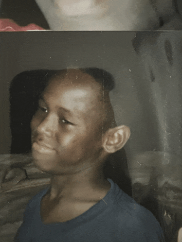 a boy in a blue shirt is sitting in a car