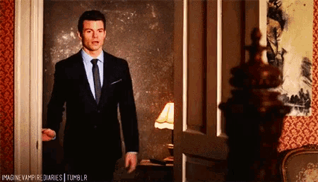 a man in a suit and tie is standing in a doorway with the words imagine vampire diaries tumblr written below him
