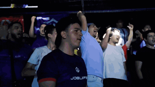 a man wearing a joblife shirt stands in a crowd of people