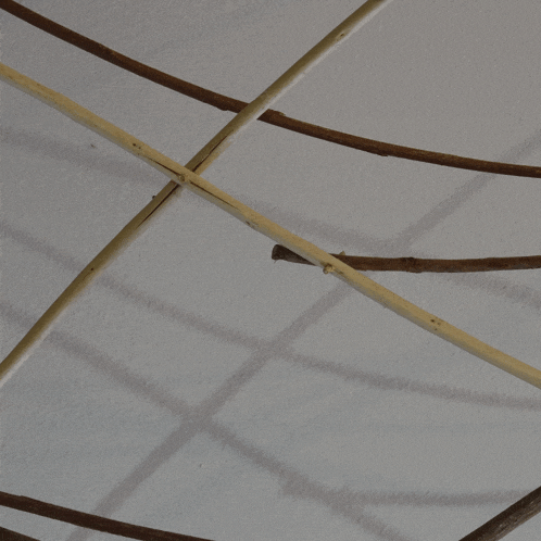 a bunch of wooden sticks are hanging from a ceiling