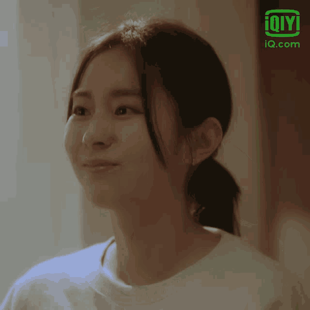 a close up of a woman 's face with an ioiyi logo in the background